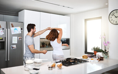 Poster - Couple, home and dancing with food in kitchen for breakfast in morning with fun, support and bonding. People, relationship and smile or happy with frying eggs or cooking for meal prep with music