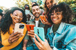 © Davide Angelini - Group of young people using smart mobile phone outdoors - Happy friends with smartphone laughing together watching funny video on social media platform - Tech and modern life style concept