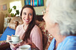 © AK Coop/peopleimages.com - Elderly mother, happy daughter and drinking coffee for bonding, reunion and conversation in home. Women, senior mom and adults with tea in living room for story, advice and family generations talking