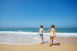 © Sergey Novikov - Young friends laughing and running on the sea shore, hold hands