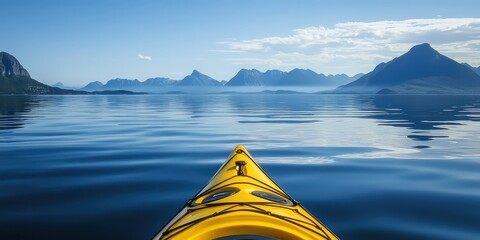 Wall Mural - A yellow kayak on calm water with mountains in the distance.