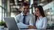 © pkproject - Two Colleagues Collaborating on a Laptop in a Corporate Office Setting