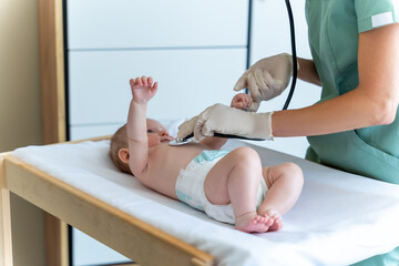 Unknown woman pediatrician conducting health checkup on the baby