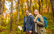 © Zoran Zeremski - Smiling couple with backpacks hiking together in forest.