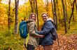 © Zoran Zeremski - Portrait of smiling couple with backpacks hiking together in forest looking at camera.