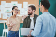 © peopleimages.com - Talking, laptop and smile in office, people and planning for project, teamwork and creative for deadline. Colleagues, confident and collaboration for journalism, newsroom and proud for discussion