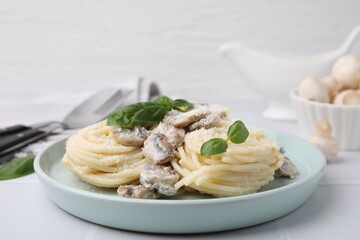 Delicious pasta with mushrooms and basil on white table, closeup