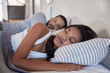 © Rido - Indian couple with closed eyes sleeping in bed together