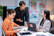 © Wasana - Asian business team having meeting discussing charts and planning new project in modern office