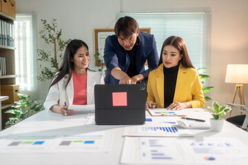 Wall Mural - Asian business team analyzing data using laptop in office meeting