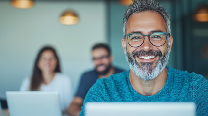 Wall Mural - Smiling man with glasses and a beard looking at the camera