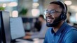 © Panuwat - Young African-American man wearing headset smiling while working Professional black male customer