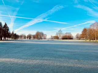 Wall Mural - Frozen Golf Course Early Morning under Bleu Sunny Sky - Concept of Winter, Sport, Weather, Nature