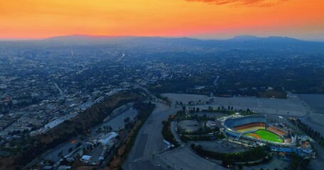 Wall Mural - Panorama of Los Angeles with Dodgers Stadium. Orange sky above the rocky horizon at backdrop. Aerial view.