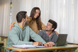 © roberto - Group of technology students, classmates two boys and a girl working together with laptop on a university or high school project, celebrating the result of the project, sharing ideas, graduate project