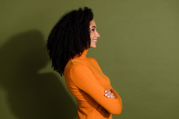 Poster - Photo of cheerful pretty lady dressed orange turtleneck arms crossed looking empty space isolated green color background