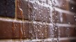 © Adnan saheem - A close-up of raindrops streaming down a waterproofed brick wall, demonstrating enhanced weather-resistant features in modern masonry