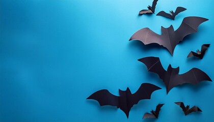 black cardboard bats on blue background, top view with space for text