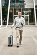 © TamJam/peopleimages.com - Business, man and walking with phone or suitcase in city for morning, commute and transport service. Professional, lawyer and luggage with mobile booking for flight schedule with travel direction
