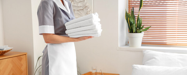 Poster - Chambermaid in uniform with clean towels at hotel room