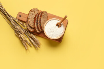 Canvas Print - Bowl with flour, bread pieces and wheat ears on yellow background