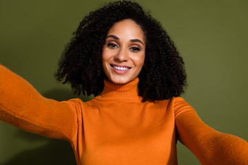 Canvas Print - Photo of good mood gorgeous woman with curly hairdo dressed orange turtleneck making selfie isolated on dark khaki color background