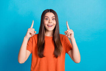 Sticker - Photo portrait of lovely teen lady point up excited empty space dressed stylish orange garment isolated on blue color background