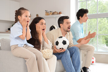 Wall Mural - Happy family with soccer ball watching football game at home