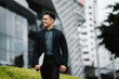 © Kritdanai - Confident City Professional: A young, successful businessman confidently strides towards his goals in a modern urban setting. He exudes confidence, ambition, and a drive to succeed.