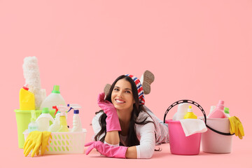 Canvas Print - Beautiful housewife with cleaning supplies lying on pink background