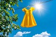 © Sanchai - A yellow sundress hanging on a clothesline, blowing in the breeze under the bright sun, symbolizing lightness and happiness