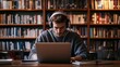 © Intania - Young Man Wearing Headphones Uses a Laptop in a Library
