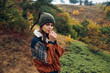 © SHOTPRIME STUDIO - A serene young woman enjoying nature in a cozy sweater and hat in the enchanting autumn forest