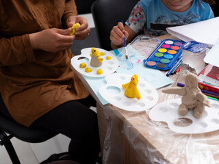 Children and adults make shapes and sculptures with play dough and draw pictures.