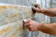 © Creative Laik - Worker tiling the wall with trowel, closeup