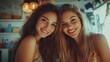 © Artyom - Two young women with long hair smiling in warmly lit room