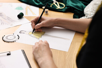 Poster - Fashion designer drawing sketch of beautiful dress at wooden table, closeup