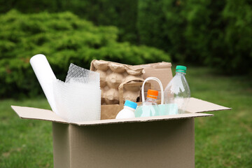 Wall Mural - Recycling. Different garbage in cardboard box outdoors