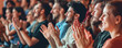 © FATHOM - Audience clapping their hands at a large event