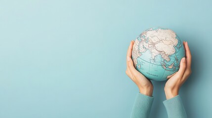 Wall Mural - Hands Holding Globe on Blue Background.