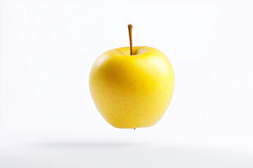 yellow apple is floating in the air. The apple is the main focus of the image, and it is in motion. The scene is simple and straightforward, with no other objects or distractions in the background