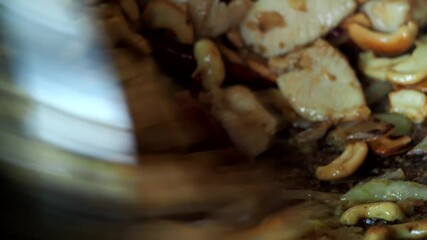 Sticker - Frying chopped chicken with cashew nuts in pan , in door  Chiangmai  Thailand.