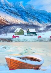 Wall Mural - red wooden boat covered with layers of snow - beautiful winter landscape with snow covered red house
