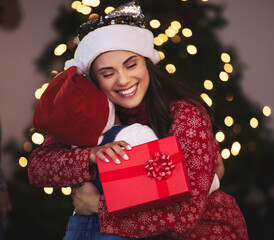 Poster - Christmas, mother and girl with gift, hug and bonding together with festive season, house and holiday. Xmas, family and parent with mama, daughter and present with embrace, vacation and celebration