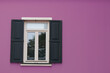 © Burak - Open wooden shutters on purple wall. Urban background idea concept. Wooden window village cottage house.