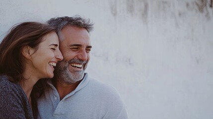 Portrait of a happy couple sharing a joyful and intimate moment, standing together with smiles on their faces. The clean background emphasizes the simplicity and purity of their connection