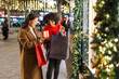 © Jordi Mora - Two young women are having fun while going christmas shopping at night in a decorated city