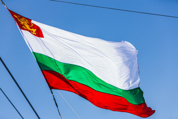 Bulgarian flag on a warship. Bulgarian flag white green and red on the background of a beautiful sky and sun rays.