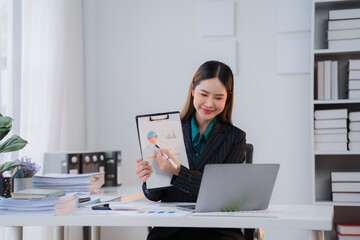 Confident Data Analyst: Young Asian businesswoman leading a virtual presentation, showcasing her expertise with a captivating smile.  