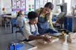© ReeldealHD images - Boy student showing teacher his project in woodworking class